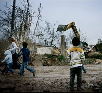 Un nio observa como una excavadora destruye hogares durante el desalojo forzoso Casilino 900, Italia, 2009